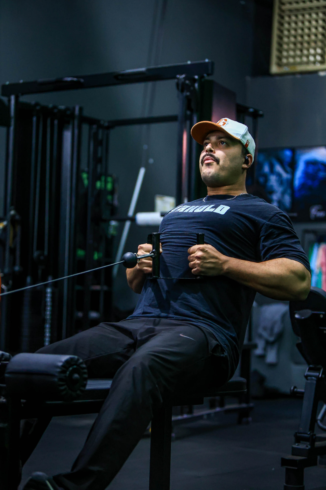 Aluno treinando força em equipamento