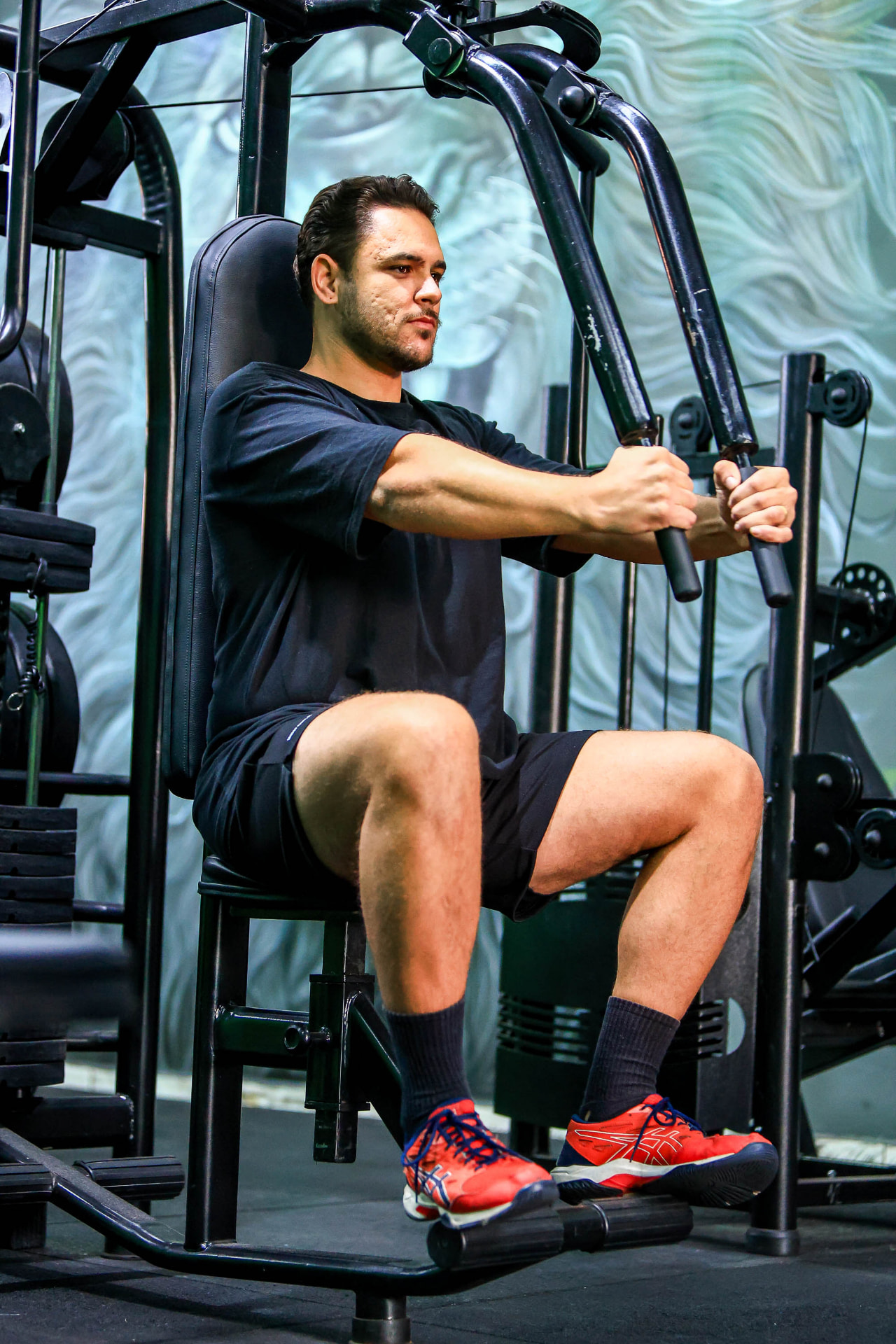 Aluno em treino de musculação guiado